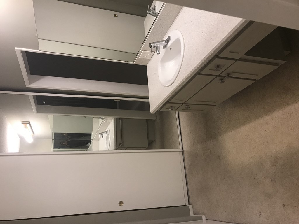 A white sink is mounted under a mirror in a bathroom.