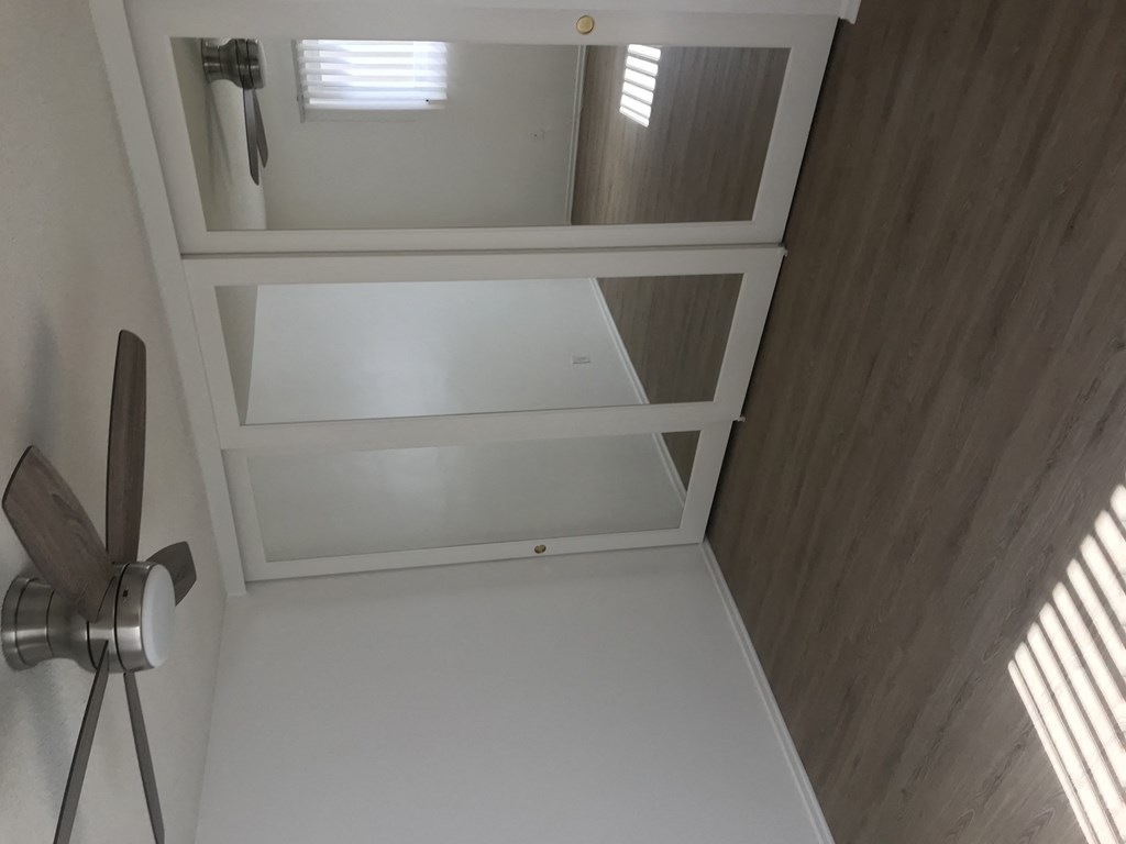 A ceiling fan in a room with a window.