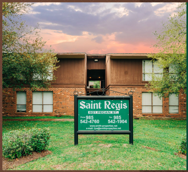 a sign in the grass in front of a building
