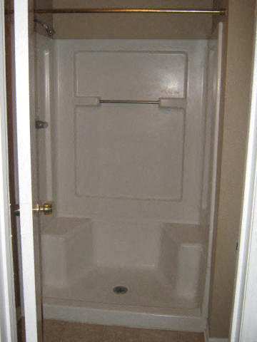 a white bathroom with a shower in the door