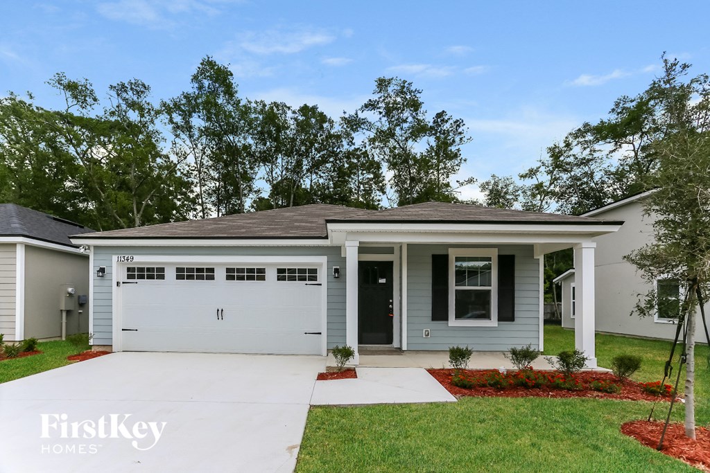 a home with a white garage door and a lawn