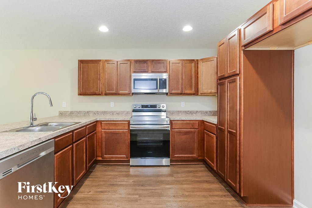 a kitchen with wooden cabinets and stainless steel appliances