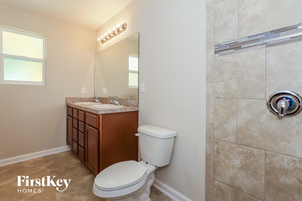a bathroom with a toilet and a shower and a sink