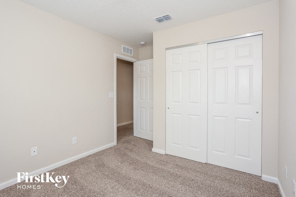 a bedroom with two closets and a carpeted floor