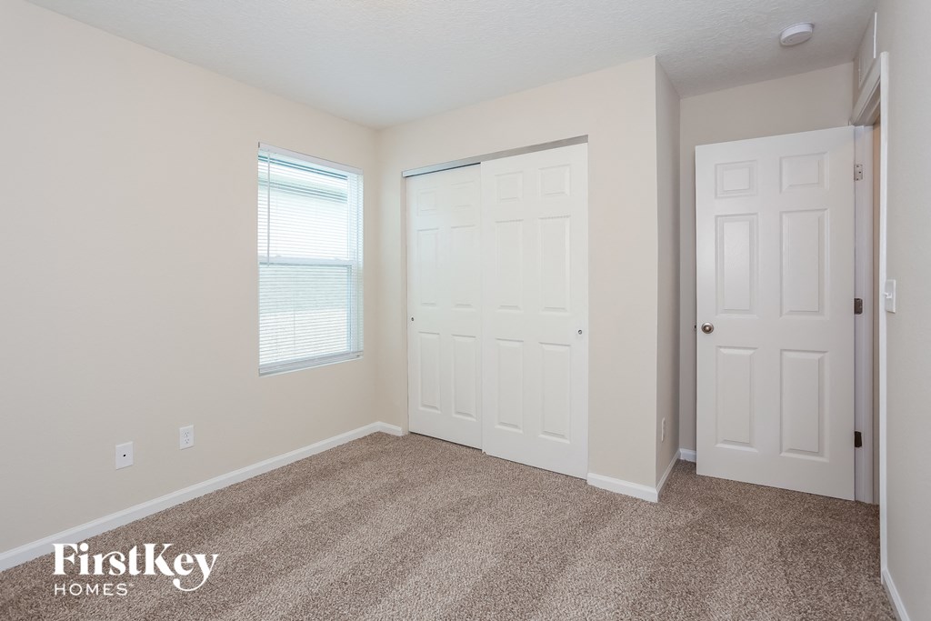 a bedroom with two white doors and a carpeted floor