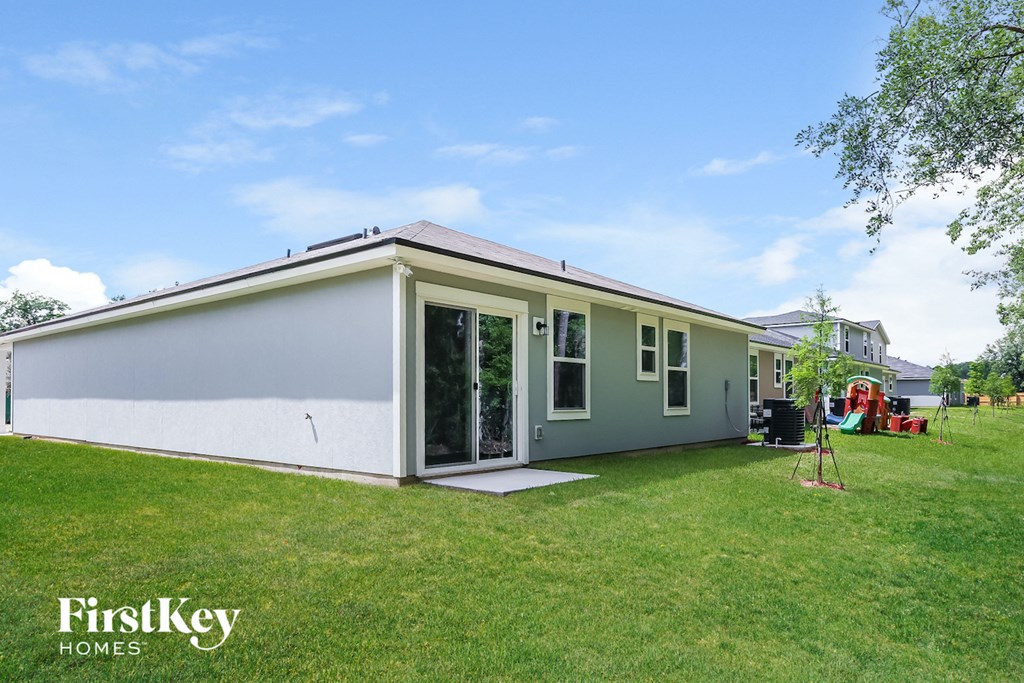 the exterior of a home with a green lawn and a white house