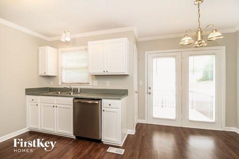 A kitchen with white cabinets and a stainless steel dishwasher.
