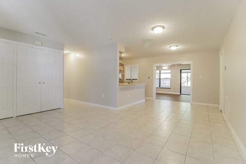 A spacious room with white cabinets and a kitchenette in the background.