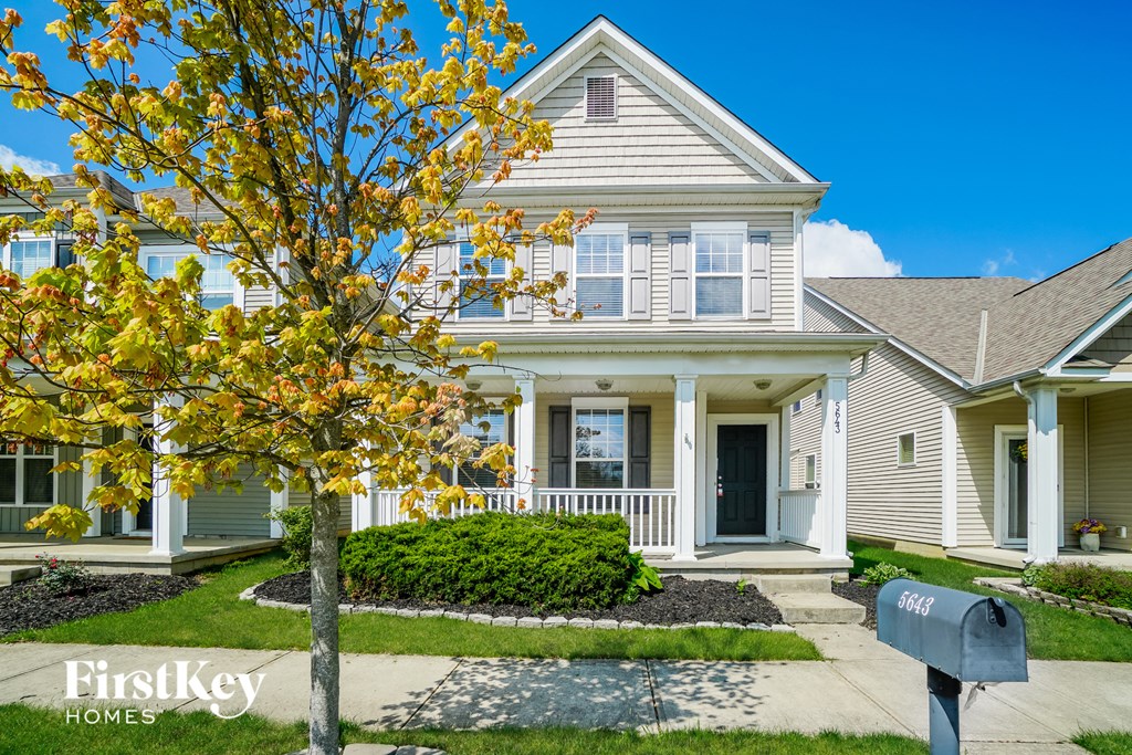 a house with a mailbox and a tree in front of it