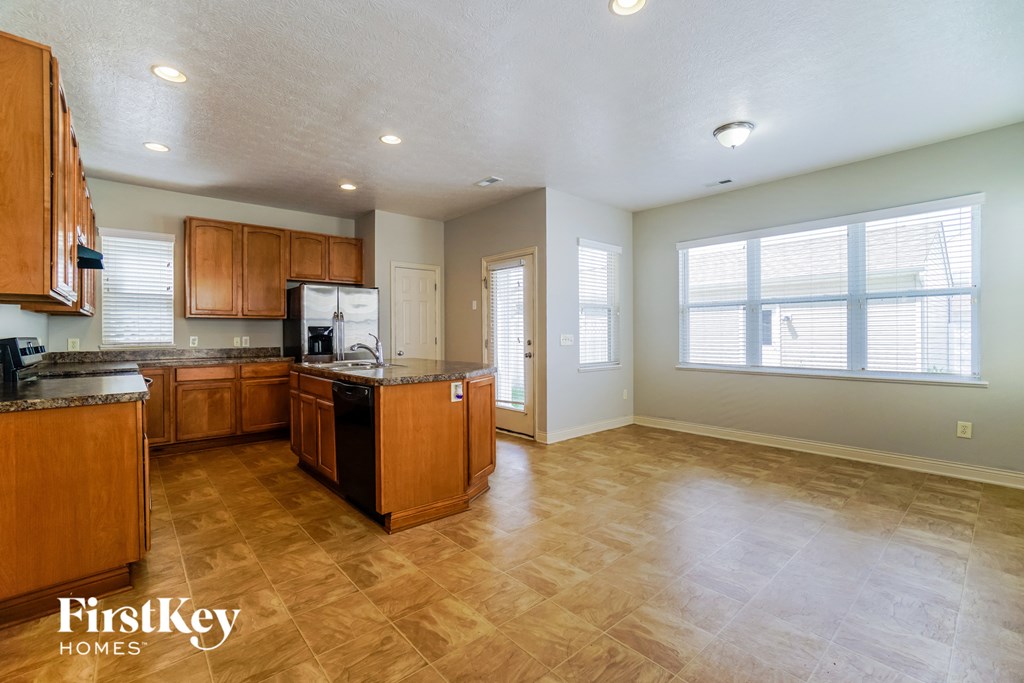 an empty kitchen with wood flooring and a large window