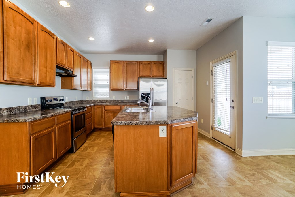 a kitchen with wooden cabinets and granite counter tops