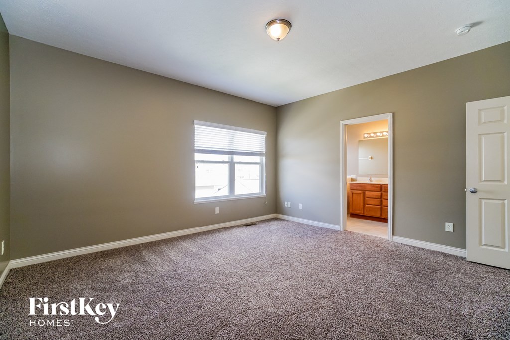 the master bedroom with carpeted flooring and a large window