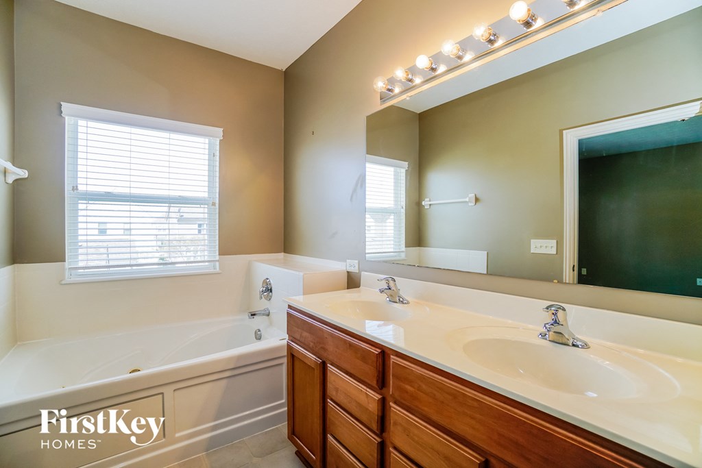 a bathroom with a sink and a tub and a mirror
