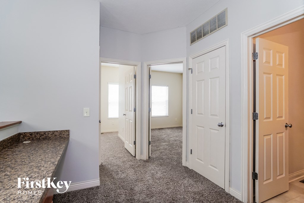 a view of a kitchen and a hallway with a door to a bedroom and a