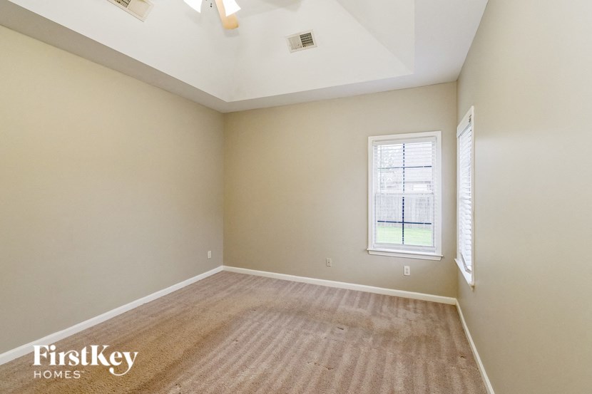 an empty room with a window and a carpet