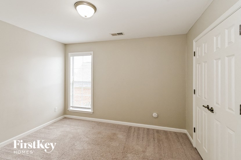 a bedroom with a white door and a window