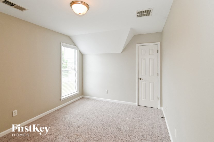an empty room with a white door and a window