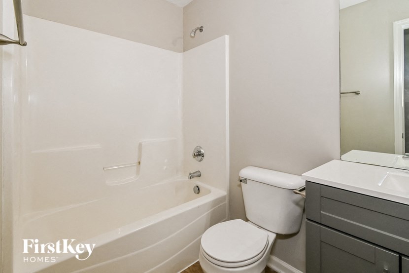 a white bathroom with a toilet and a tub