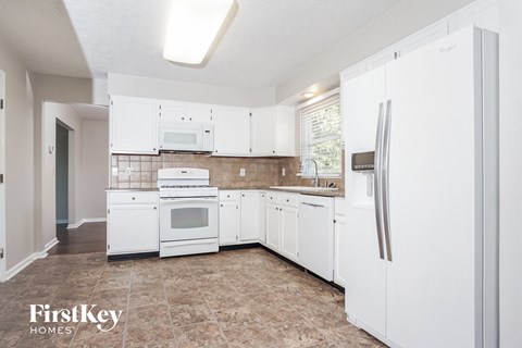 a white kitchen with white appliances and white cabinets