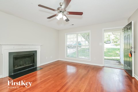 A room with a fireplace and a ceiling fan.