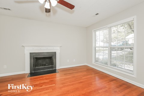 A room with a fireplace and a ceiling fan.