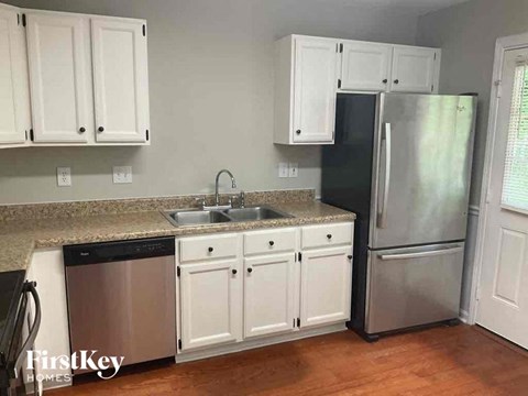 a kitchen with white cabinets and a stainless steel refrigerator