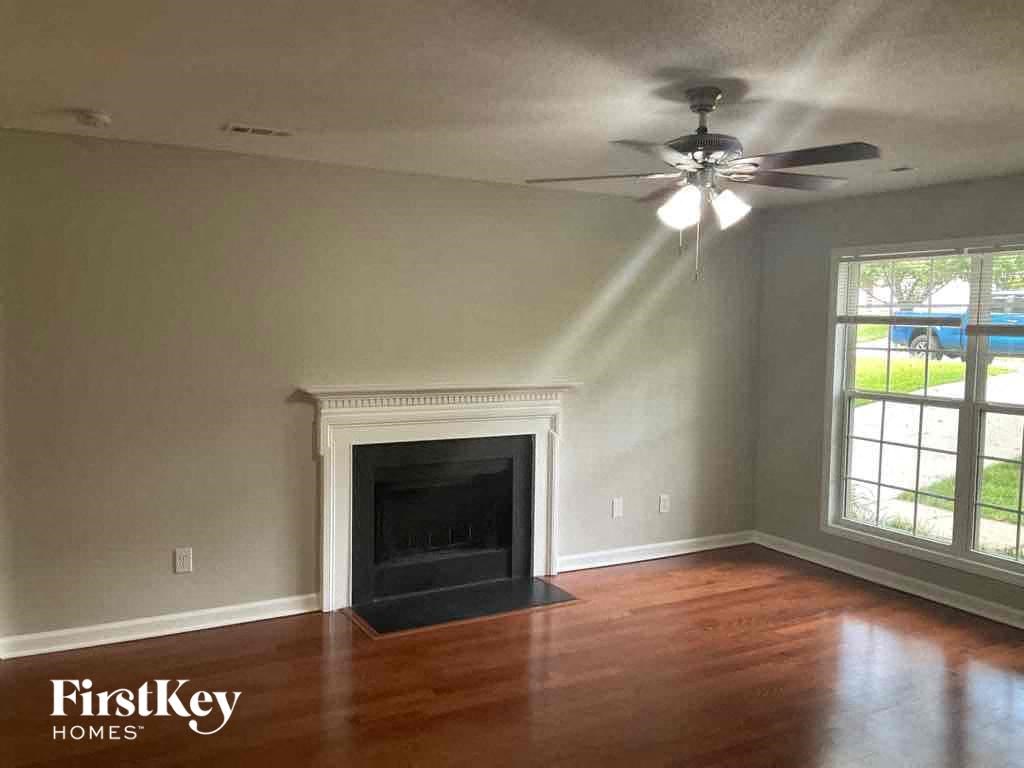a living room with a fireplace and a ceiling fan