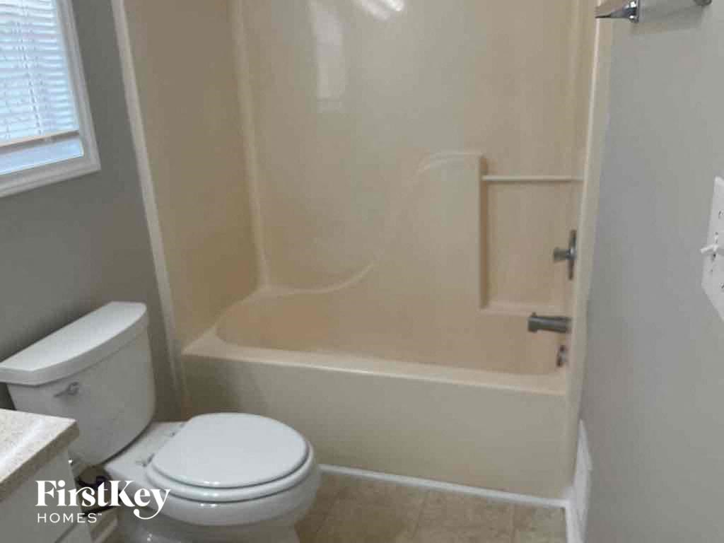 a small bathroom with a toilet and a bath tub