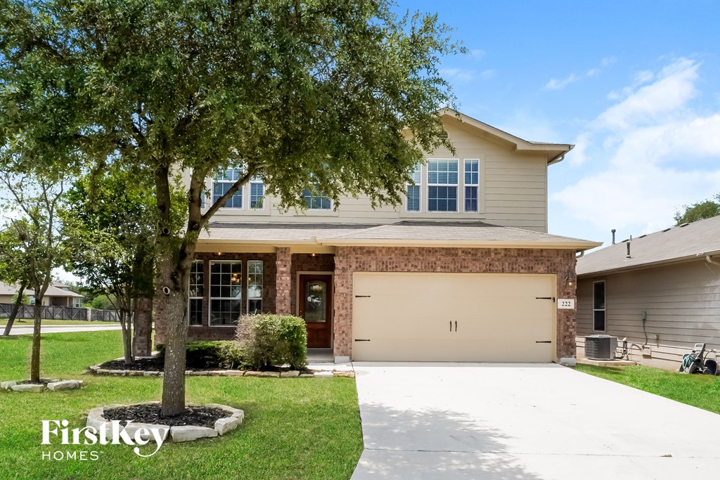 a house with a garage door and a tree