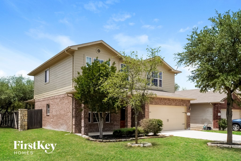 a beige house with a garage and trees