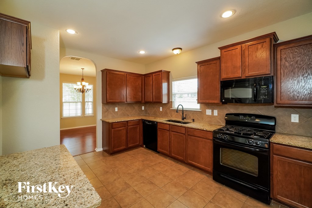 a kitchen with wooden cabinets and black appliances
