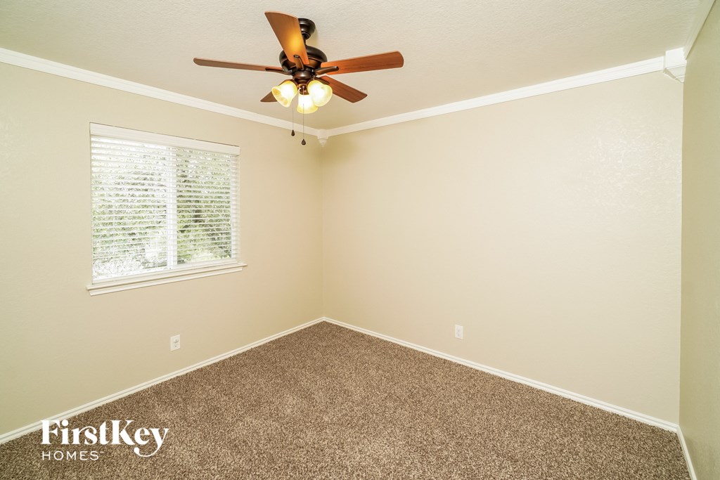 a bedroom with a ceiling fan and a window