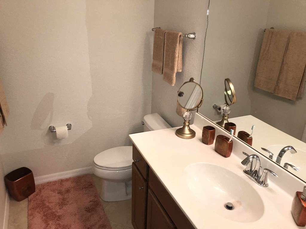 A bathroom with a toilet, sink, and towel rack.