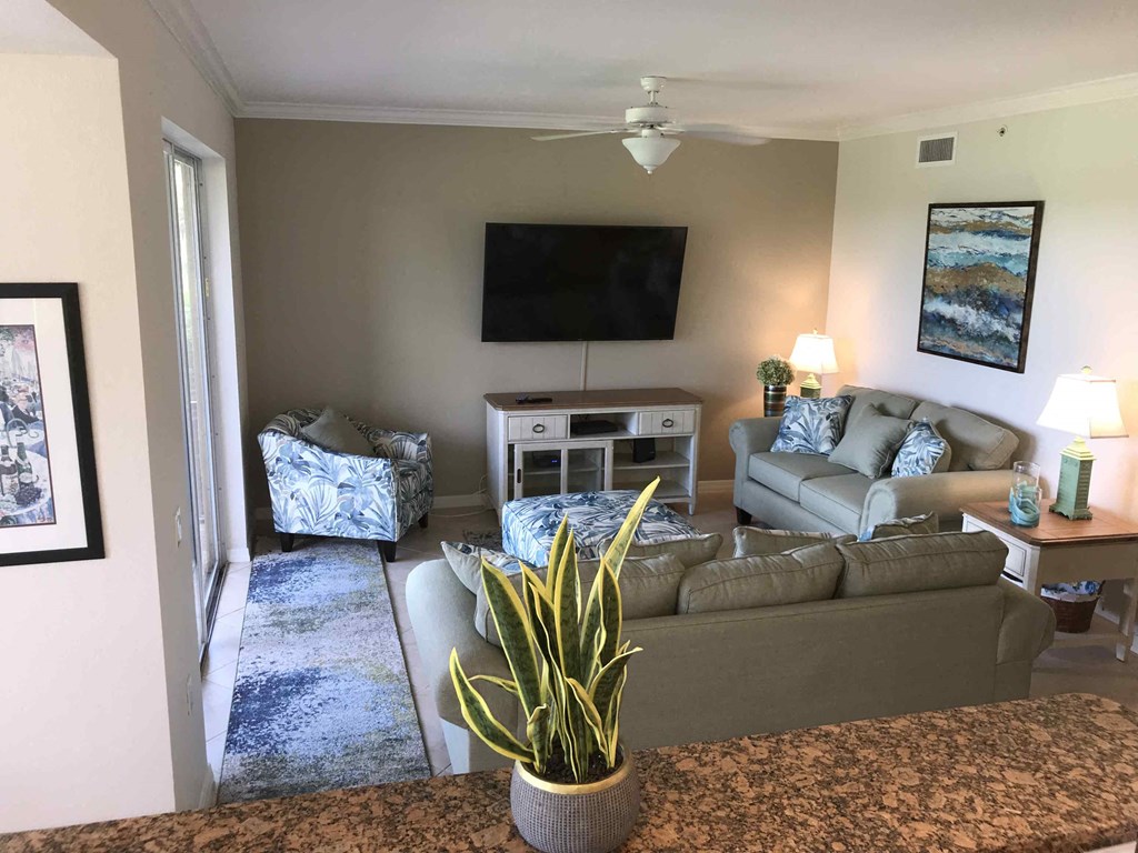 A living room with a couch, chair, and television.