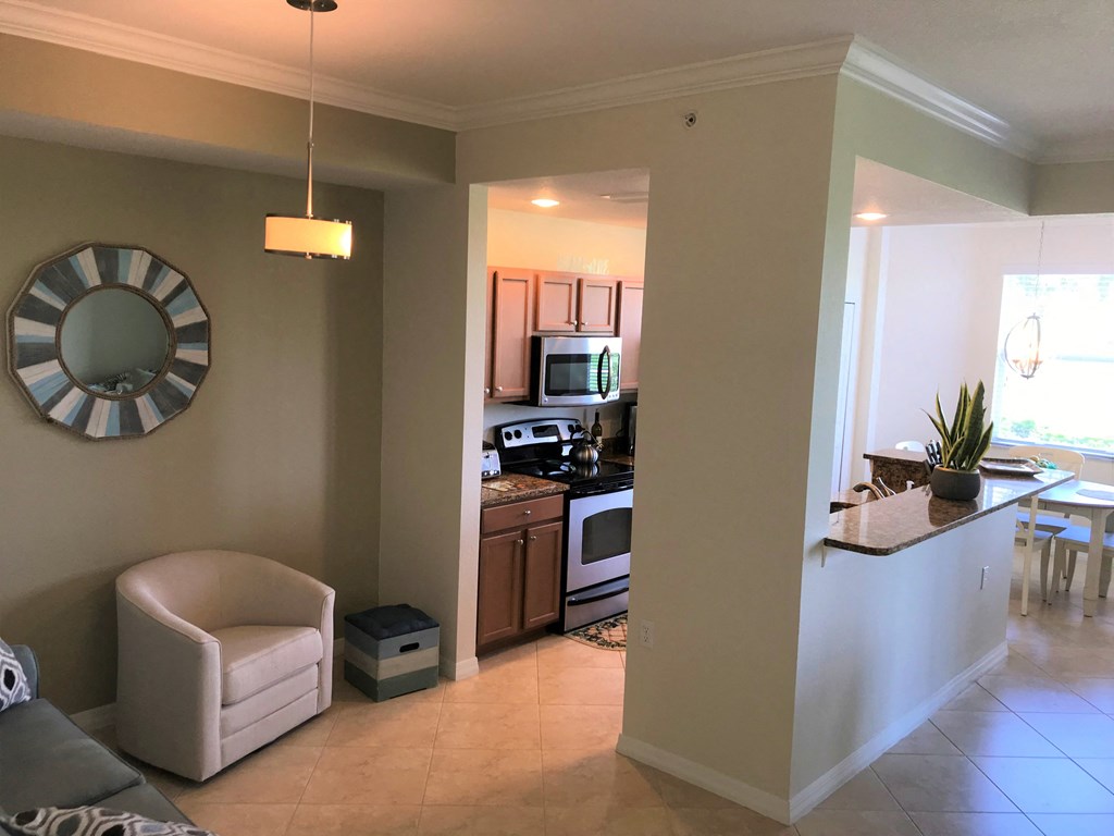 A living room with a chair and a clock on the wall.
