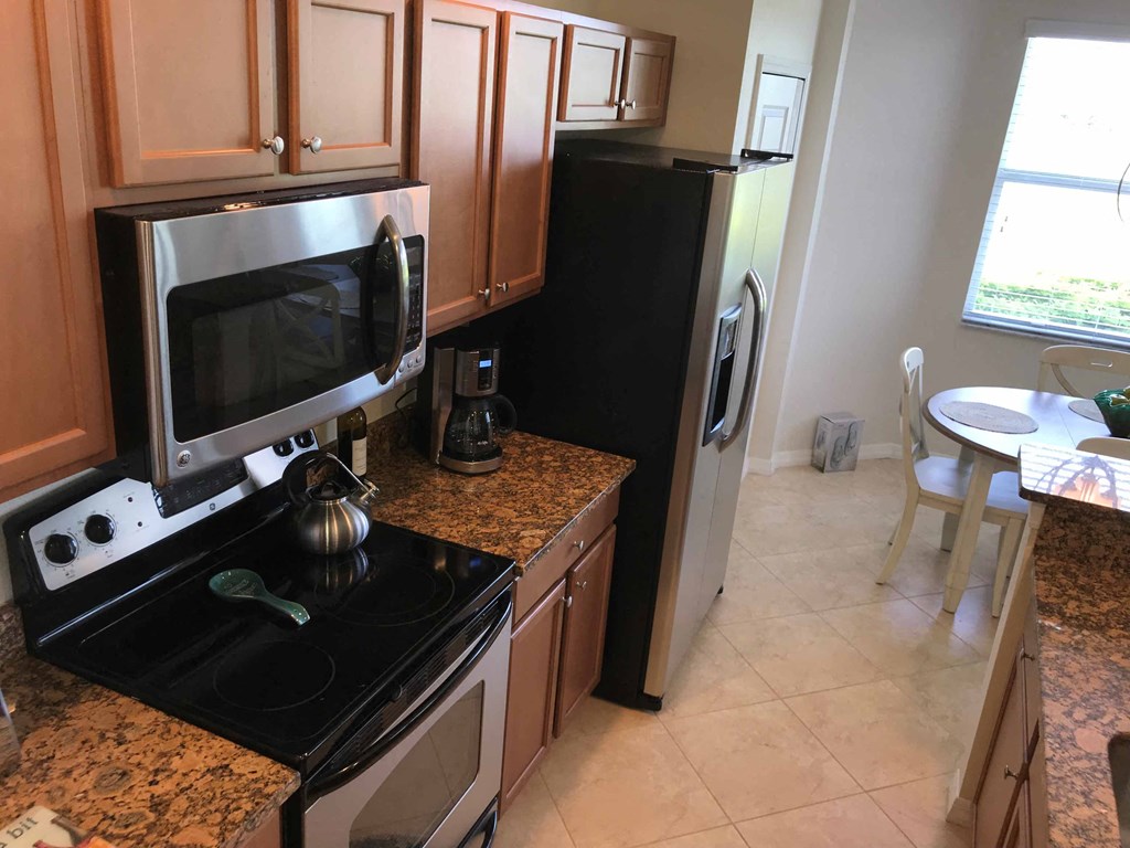 A kitchen with black appliances and granite countertops.
