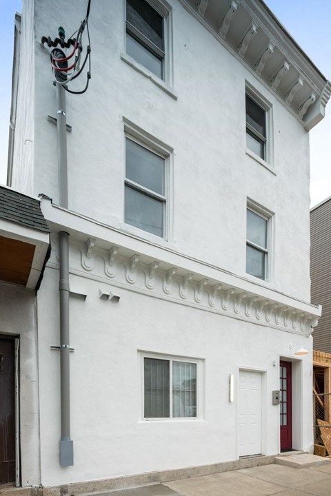 the exterior of a white building with windows and a street light