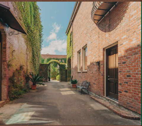 a courtyard with a bench and a brick building