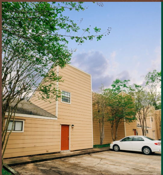 a yellow house with a red door and a white car parked outside
