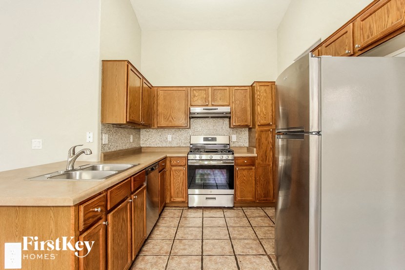 a kitchen with wooden cabinets and stainless steel appliances