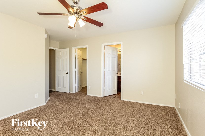 a bedroom with a ceiling fan and a carpeted floor