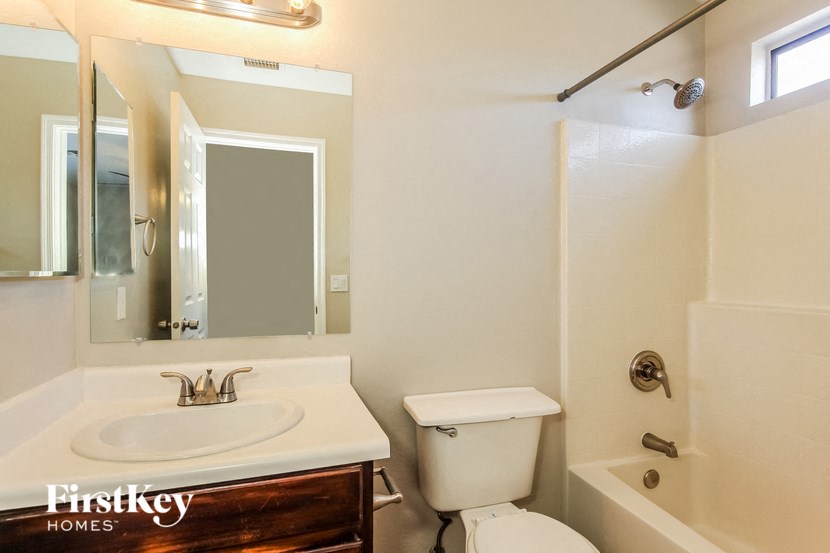 a bathroom with a sink toilet and a mirror