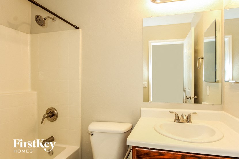 a bathroom with a sink toilet and a mirror