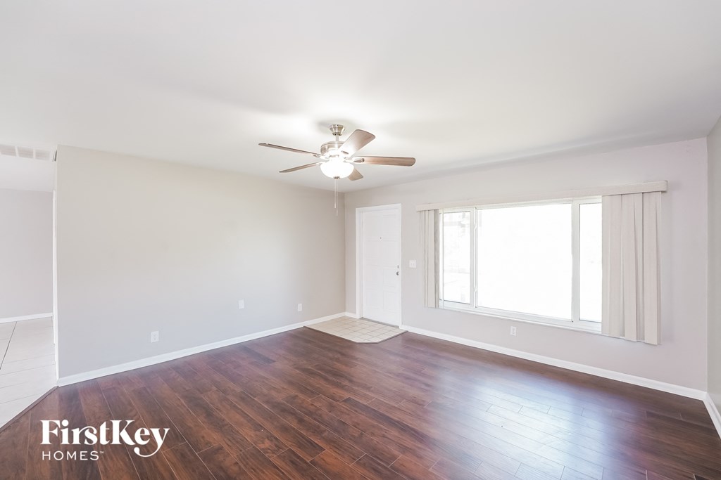 a living room with wood floors and a ceiling fan