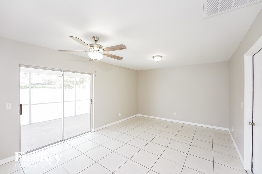 a clean and empty living room with a ceiling fan