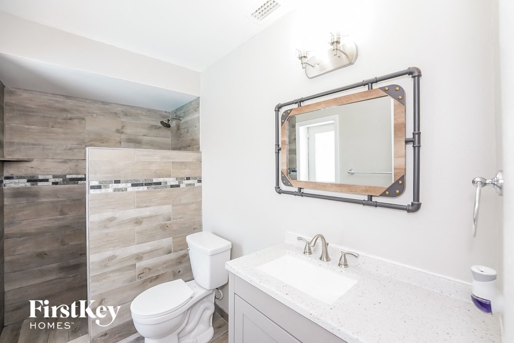 a bathroom with a toilet and a sink and a mirror