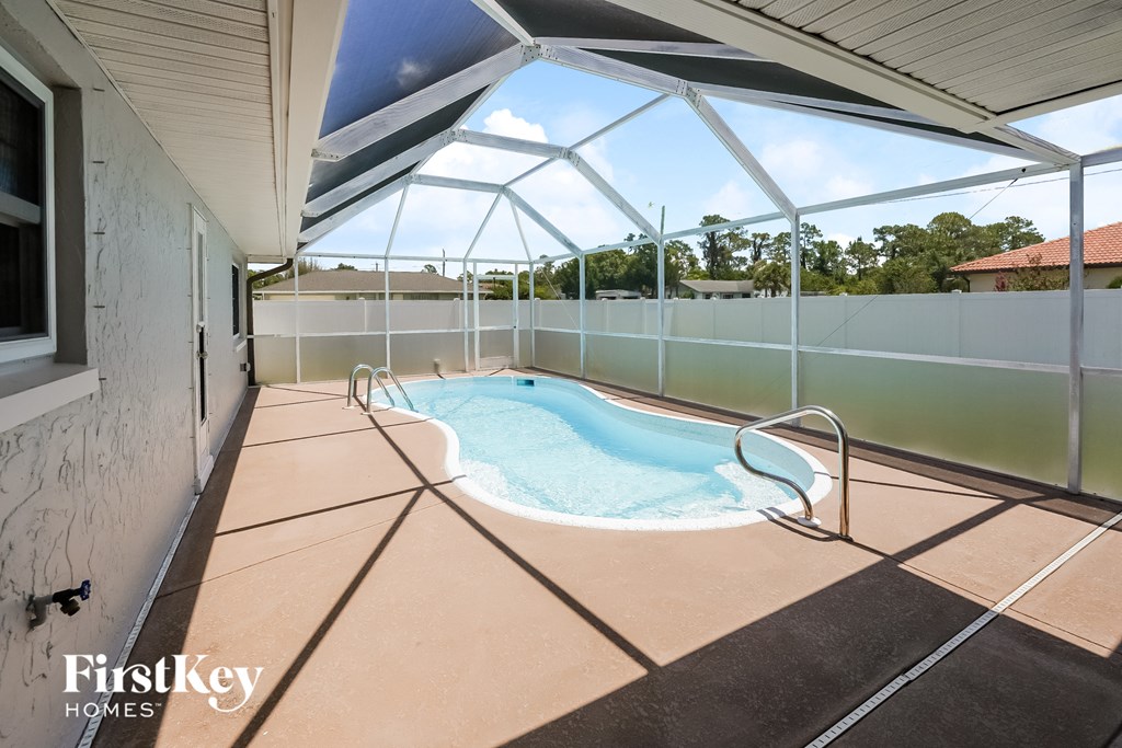 a hot tub in the patio of a house with a pool