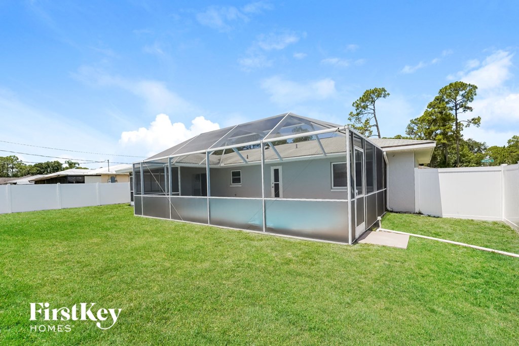 a large greenhouse in a backyard with a green lawn