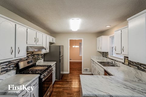 a kitchen with white cabinets and stainless steel appliances