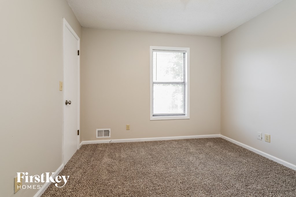 a empty room with carpet and a window